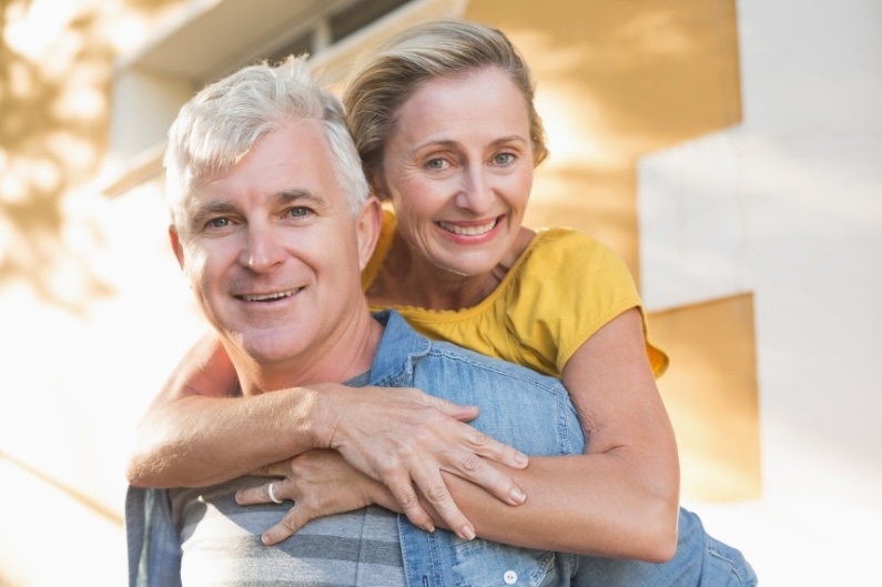 Happy pre-retiree couple smiling outdoors, enjoying lifestyle freedom while planning and test-driving retirement
